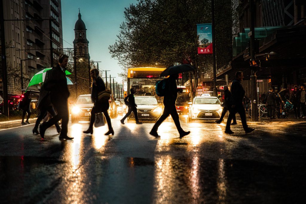People-walking-on-pedestrain-lane-during-a-rainy-evening
