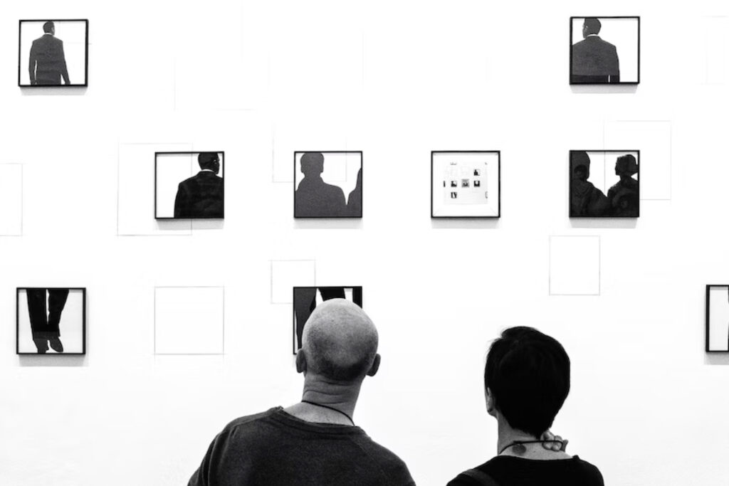 Art museum benefits two people looking at wall black white with photography