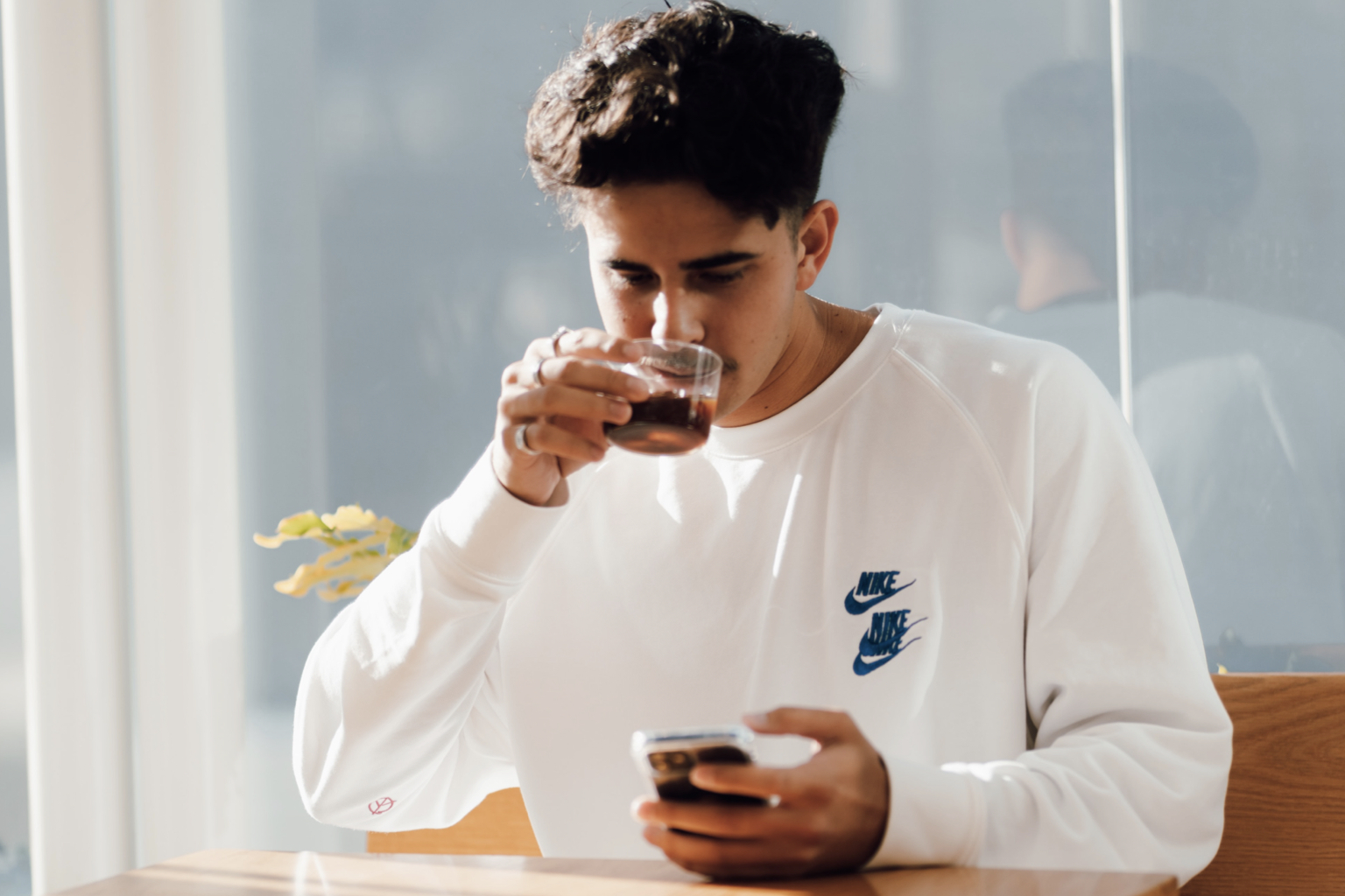 boy on phone while drinking tea
