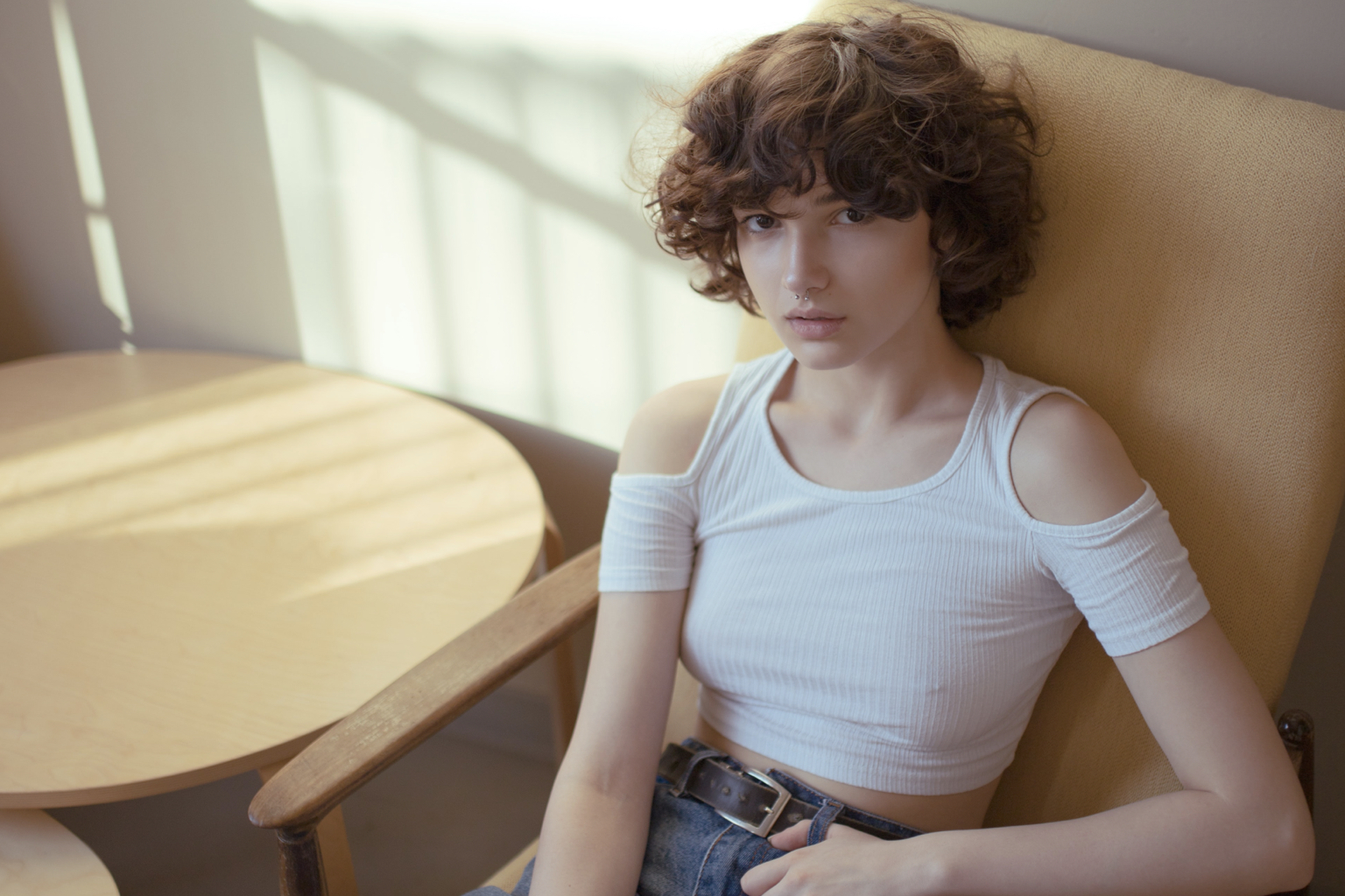 women sitting on a chair short curly hair